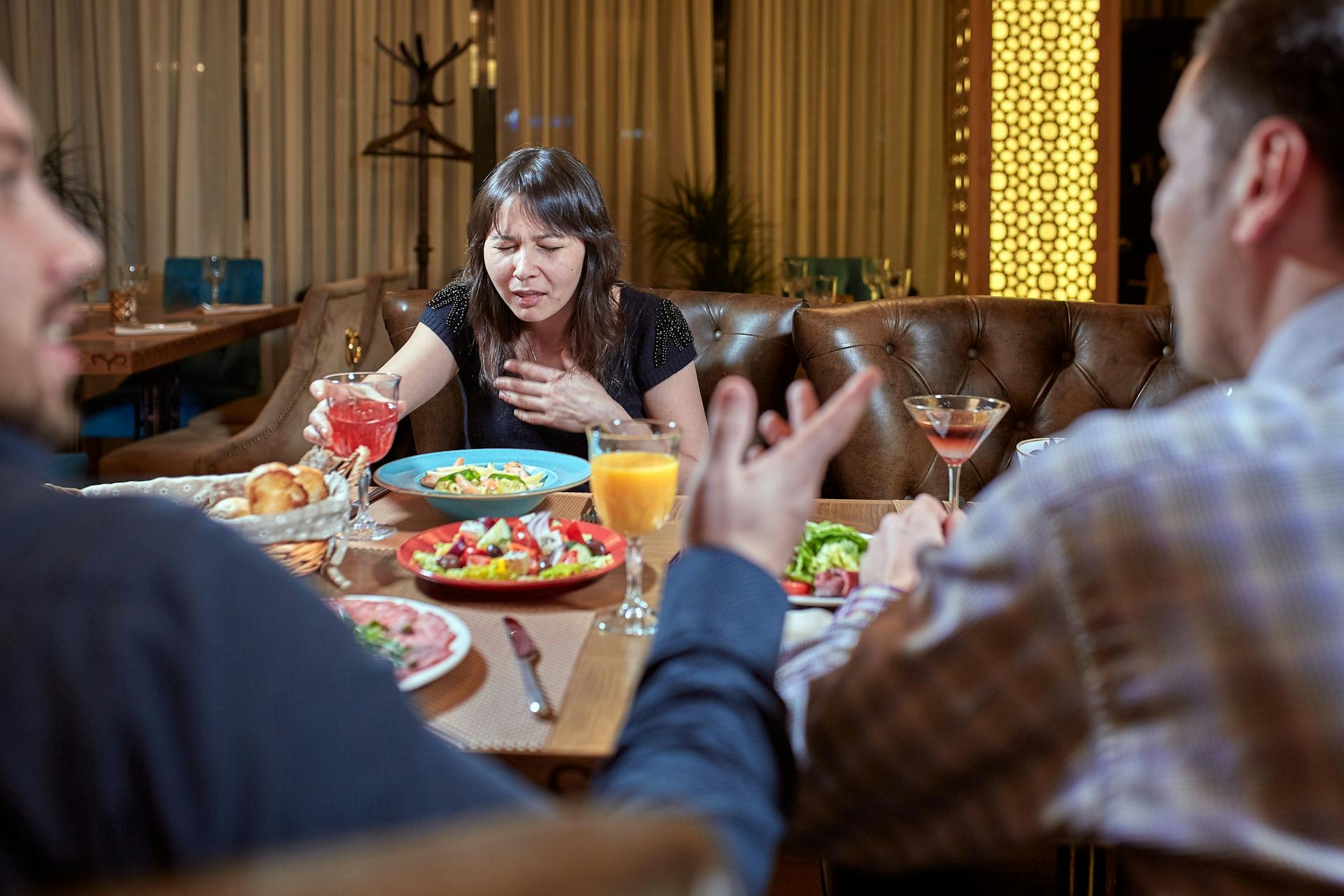 A table filled with people savoring a meal, highlighting the significance of considering food allergies when dining out.