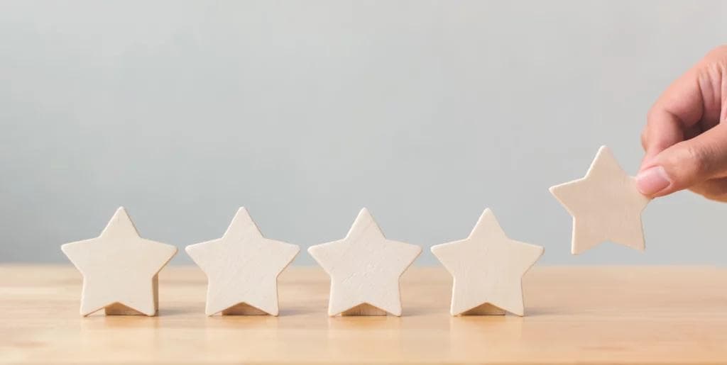 A person holding a star-shaped piece of wood for a menu decoration
