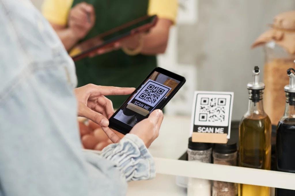A QR code displayed on a smartphone indicating the availability of QR Code-Based Payments