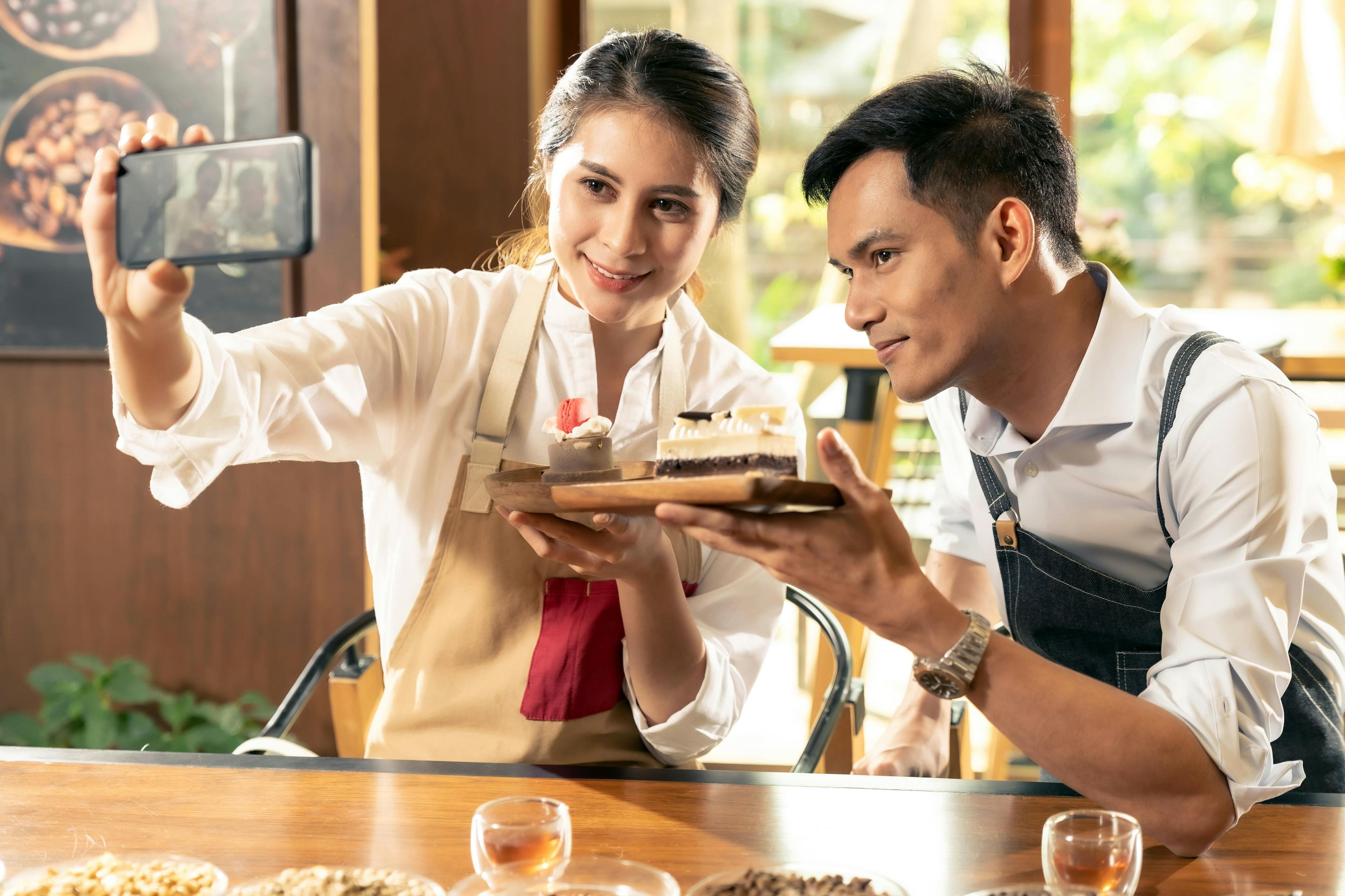 An image of a man and woman photographing a dessert, promoting it through marketing