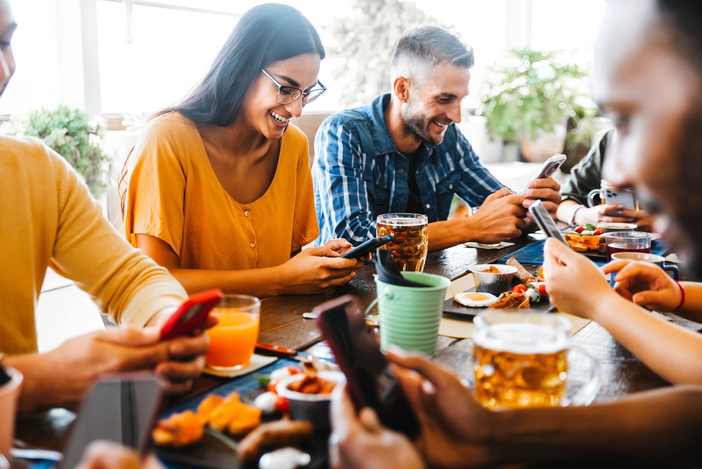 People using phones for tableside ordering at a restaurant.