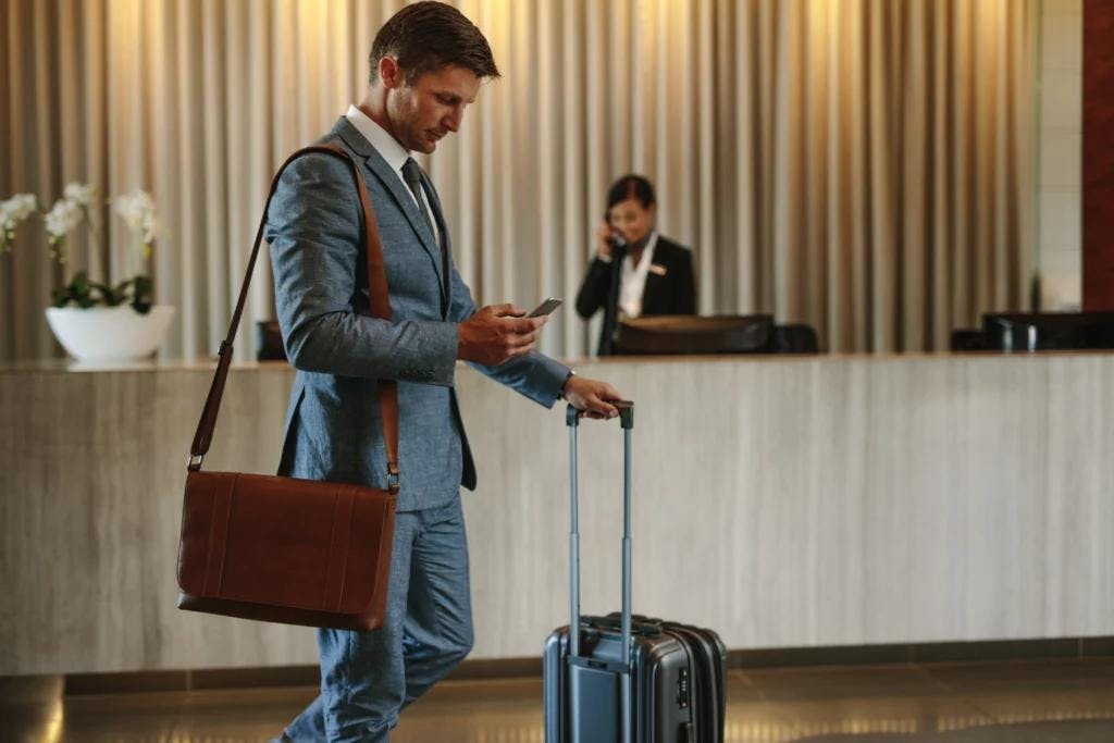 Businessman with suitcase walking browsing the QR Code.
